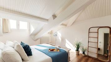 A bedroom with a bed, bedside table, and a mirror.