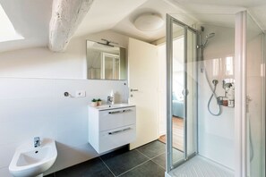 A modern bathroom with a glass shower enclosure, a white vanity with a mirror, and a bidet. - Como in the Sky (Como)