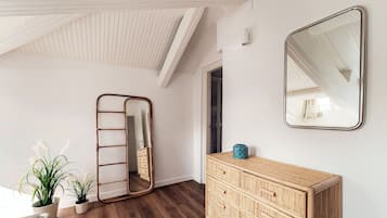 Ein Zimmer mit einem Holzschrank, einem Spiegel und einer Leiter.