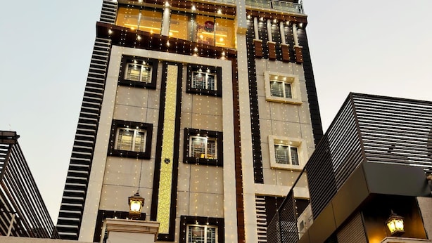 Un hotel con un cartel llamativo, varias ventanas y una entrada bien iluminada.