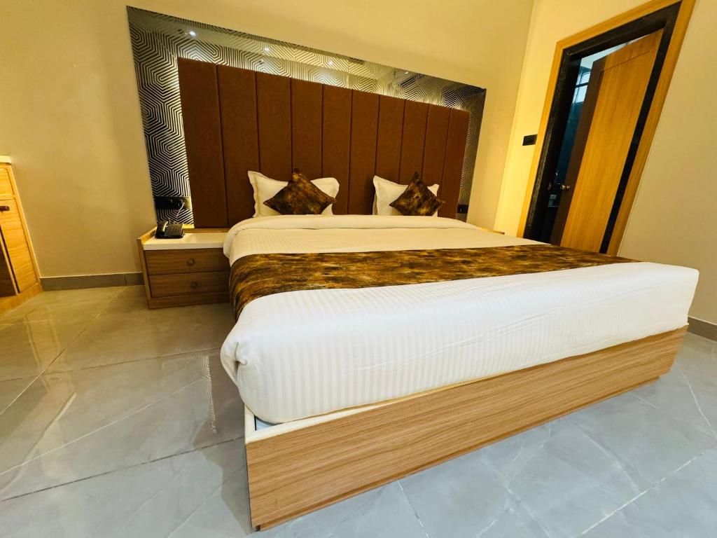 Un dormitorio moderno con una cama grande, cabecera de madera y una mesita de noche.