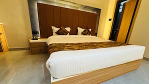 Un dormitorio moderno con una cama grande, cabecera de madera y una mesita de noche.