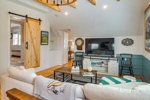 A cozy living room with a sofa, coffee table, and a TV. - Walk to Main St! Osterville Cottage w/ Patio (Osterville)