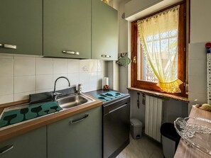 Eine kleine Küche mit Spüle, Herd und Schränken.