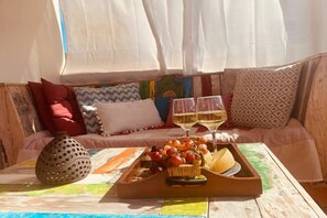 A cozy seating area with a tray of fruits and glasses of wine, a decorative vase, and a colorful tablecloth. - Villa in Pitsidia with swimming pool (Pitsidia)