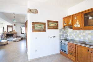 A kitchen with wooden cabinets, a tiled backsplash, and a built-in oven. - Villa in Pitsidia with swimming pool (Pitsidia)