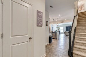 Ein modernes Interieur mit einer weißen Tür, einer Küchenzeile und einer Treppe.