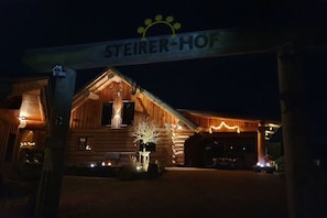 Een hotel in een blokhut met een bordje dat 'STEIERER-HOF' zegt bij de ingang.
