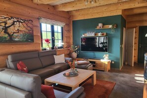 Een gezellige woonkamer met een bank, salontafel en een flatscreen televisie.