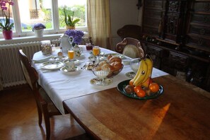 A breakfast table set with plates, cups, a fruit bowl, and a kettle. - Apartment in Lindau with swimming pool (Lindau)