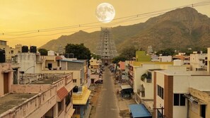 A street view with a prominent temple in the distance, surrounded by residential buildings. - Maruti residency (Tiruvannamalai)