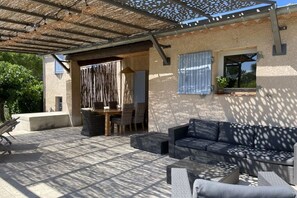 An outdoor patio with a sofa, dining table, and chairs. - Holiday home in Provence (Merindol)