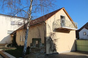 A two-story building with a balcony, a stone staircase, and a gated entrance. - Holiday apartment with 2 bedrooms (Bamberg)
