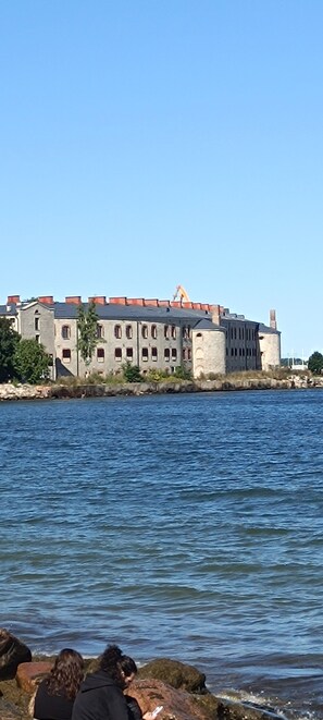 A waterfront building with multiple windows and a stone facade. - Kalaranna family & business (Tallinn)