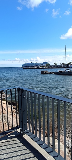 A waterfront view with a dock, a bridge, and a cruise ship in the distance. - Kalaranna family & business (Tallinn)