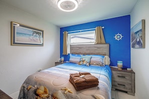 A bedroom with a bed, a nightstand, a window with curtains, a wall clock, and a framed picture. - 'Trop Rock Inn' Outdoor Oasis & Music Studio (Melbourne)