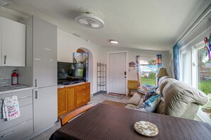 A compact living space with a kitchenette, a dining area, and a seating area with a view. - 'Trop Rock Inn' Outdoor Oasis & Music Studio (Melbourne)