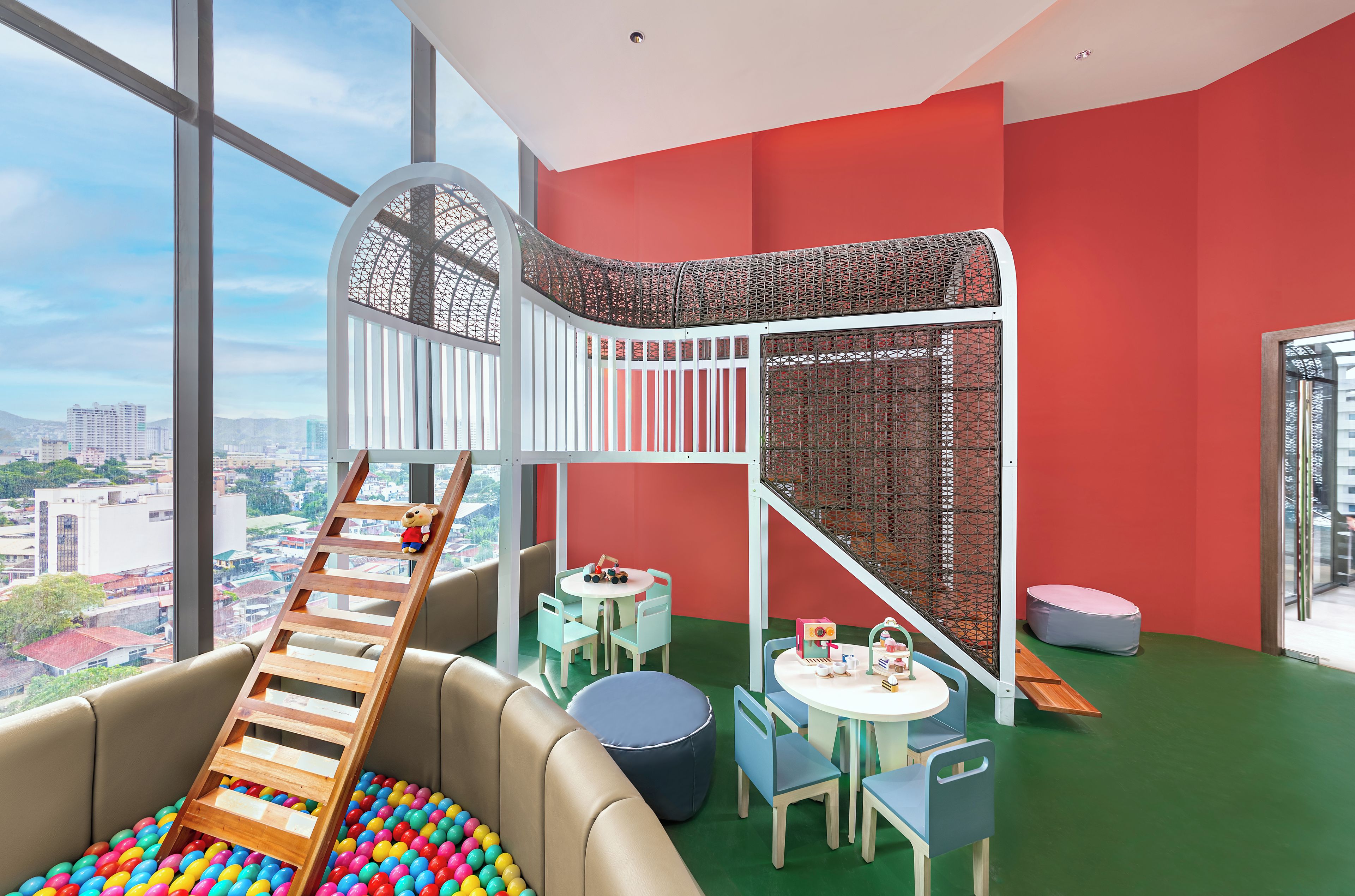 A children's play area with a slide, ball pit, and seating.