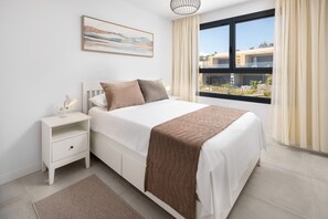A bedroom with a bed, nightstand, lamp, and a painting on the wall. - Evergreen Luxury Sea Views | 4BR & Pool by Alfresco Stays (Mijas)