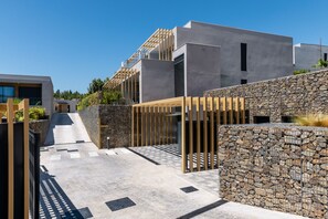 Un bâtiment moderne doté d’un toit plat, d’un mur en pierre et d’une clôture en bois.