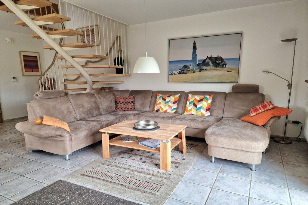 A living room with a sofa, coffee table, and a staircase.