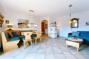 Ein Wohnzimmer mit einer Couch, einem Esstisch, Stühlen und einem Couchtisch.