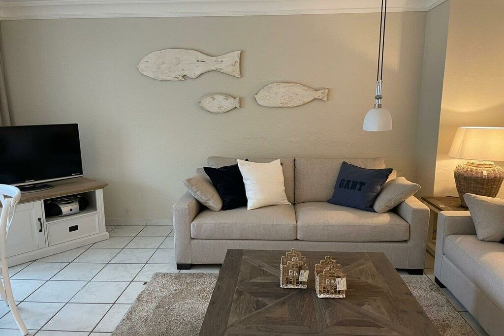 A living room with a sofa, a coffee table, and wall-mounted fish decorations.