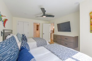 A bedroom with a bed, bedside tables, a dresser, a ceiling fan, and a TV on the wall. - Steps to Blue Mountain Beach! 30A Getaway w/ Deck (Santa Rosa Beach)