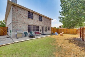 A two-story brick house with a patio, a grill, and outdoor furniture. - 9BR Group Getaway Outside Fort Worth (Justin)