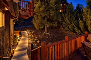 Une terrasse en bois avec un chemin de pierre menant à un bâtiment.