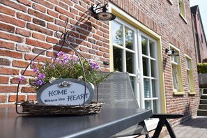 Ein Backsteinhaus mit einem Fenster und einem Schild, auf dem steht: 'HOME IS Where the HEART IS.'
