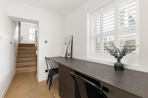 A modern kitchen with a dark countertop, a built-in stove, and a window with blinds. - New! Charming 2BR | Parking | Brockley (Greater London)