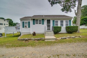 A single-story house with a front porch, a stone border, and a potted plant. - Walk to Swift's Beach! Cozy Home Near Cape Cod (Wareham)