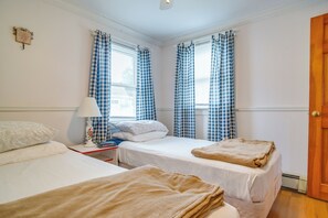 A hotel room with two beds, a bedside table with a lamp, and a clock. - Walk to Swift's Beach! Cozy Home Near Cape Cod (Wareham)