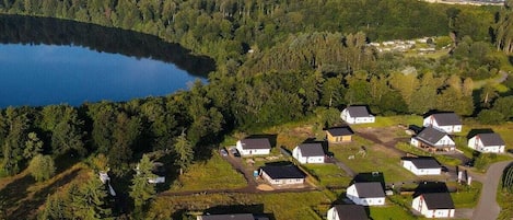 Vista aérea de una zona residencial con casas, un lago y un paisaje boscoso.