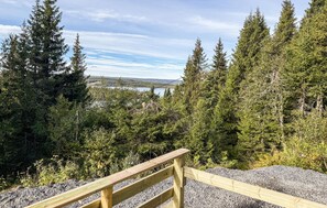 A wooden viewing platform overlooking a forested area with a lake and distant hills. - 3 bedroom stunning home in Svingvoll (Svingvoll)