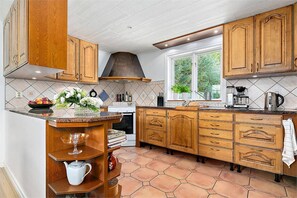 Una cocina con armarios de madera, una isla central y un ventanal con vistas.