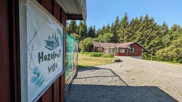 A red building with a gravel driveway and a sign reading 'Hazelnut Villa.'