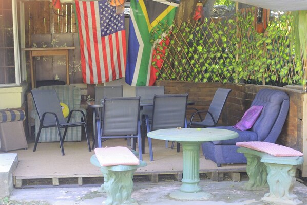 An outdoor seating area with chairs and tables, a decorative fence, and flags.