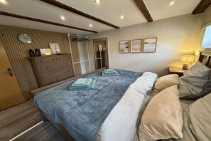 Ein Schlafzimmer mit Bett, Nachttischen, einem Kleiderschrank und einem Spiegel.
