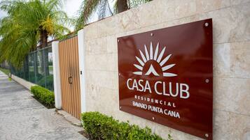 Ein Schild mit der Aufschrift 'CASA CLUB RESIDENCIAL BAVARO PUNTA CANA' inklusive Logo, angebracht an einer wandförmigen Fläche mit Fliesen.