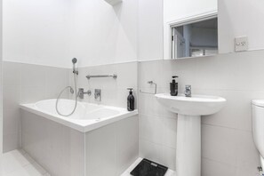 Ein modernes Badezimmer mit einer Badewanne, einem Waschbecken und einer Toilette.