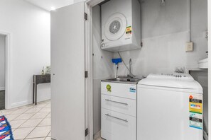 A laundry room with a washing machine, a dryer, and a ventilation system. - Large Waterfront Stay by Britomart & Harbour (Auckland city)