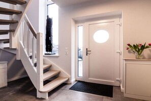 Eine Treppe führt zu einer Zwischenebene mit einer Tür und einem Fenster.