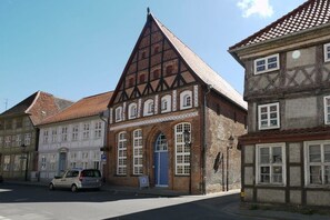 A traditional half-timbered building with a steeply pitched roof, arched windows, and a blue door. - Holiday apartment in Trebel with barbecue (Trebel)