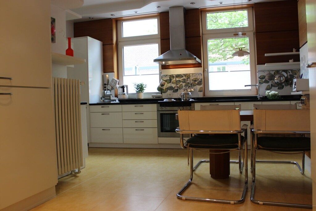 A modern kitchen with a central island, built-in appliances, and large windows.
