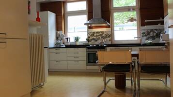 A modern kitchen with a central island, built-in appliances, and large windows.