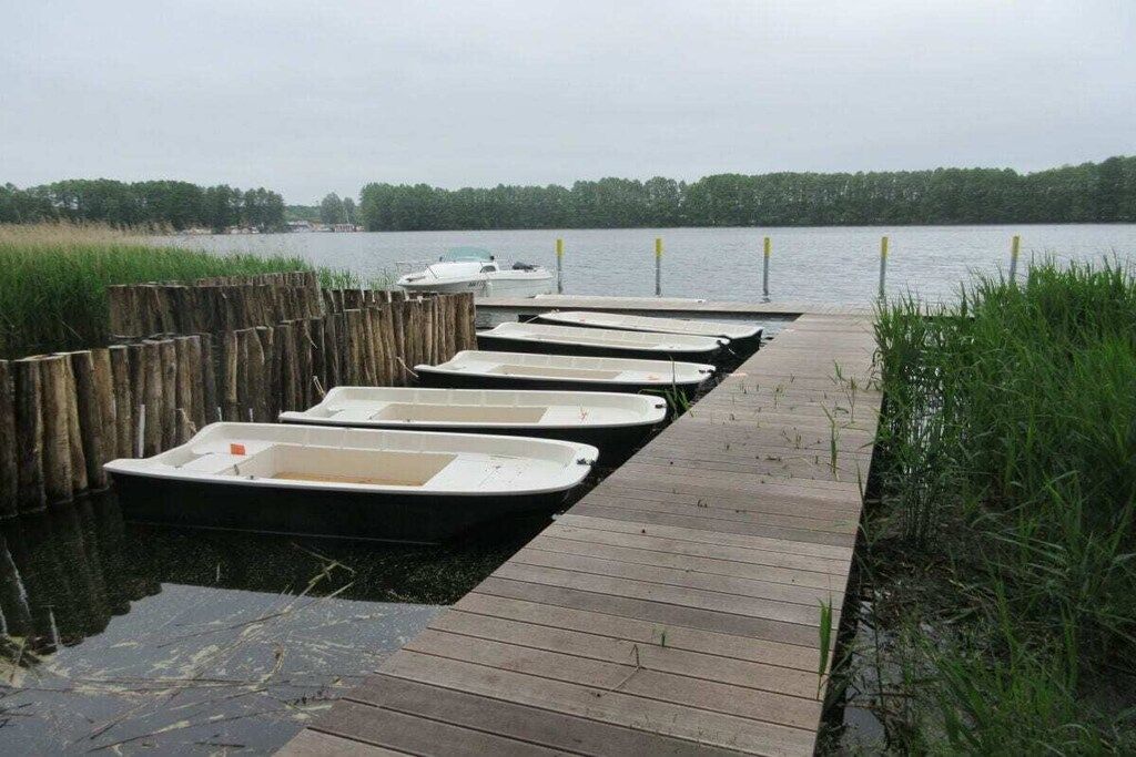 A wooden dock with several small boats moored at the end.