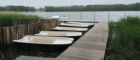 A wooden dock with several small boats moored at the end.