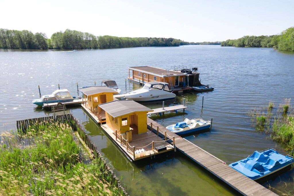 Un quai où sont amarrés plusieurs bateaux, ainsi qu’une petite construction en bois.